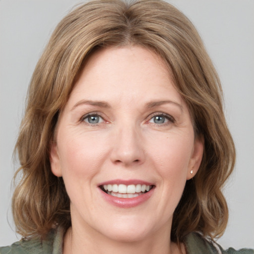 Joyful white adult female with medium  brown hair and green eyes