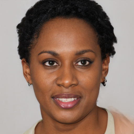Joyful black young-adult female with short  black hair and brown eyes