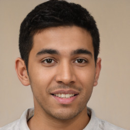 Joyful latino young-adult male with short  brown hair and brown eyes