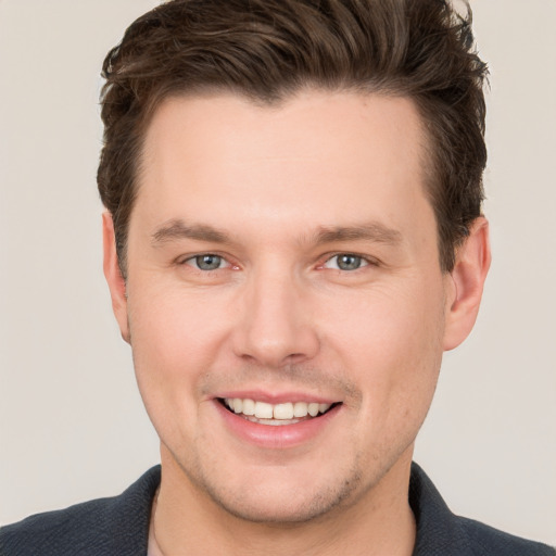 Joyful white young-adult male with short  brown hair and grey eyes