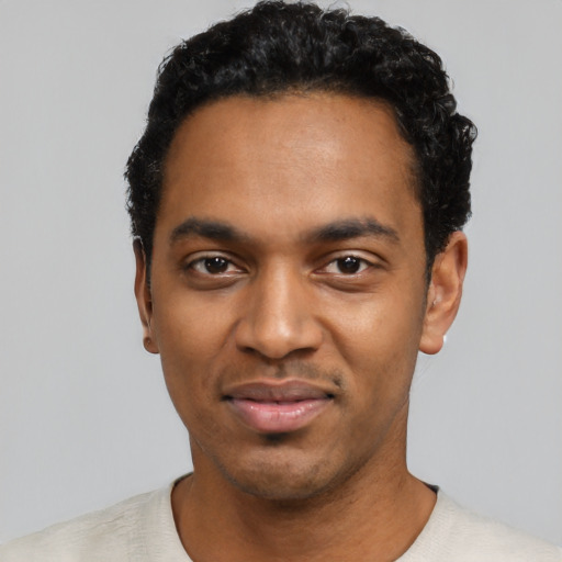 Joyful black young-adult male with short  black hair and brown eyes