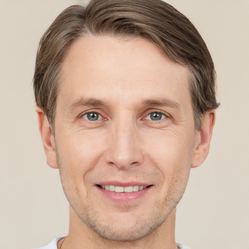 Joyful white adult male with short  brown hair and grey eyes