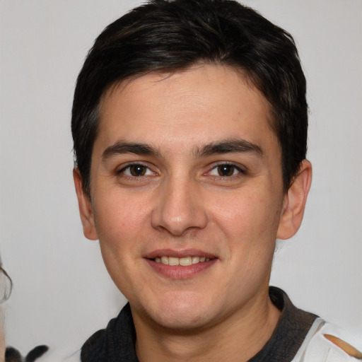 Joyful white young-adult male with short  brown hair and brown eyes