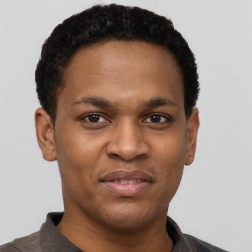 Joyful black young-adult male with short  brown hair and brown eyes