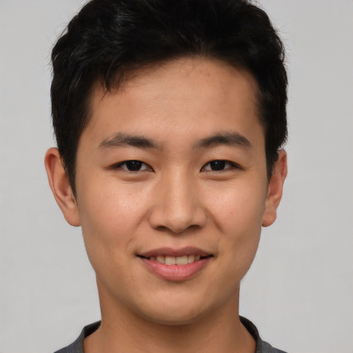 Joyful asian young-adult male with short  brown hair and brown eyes