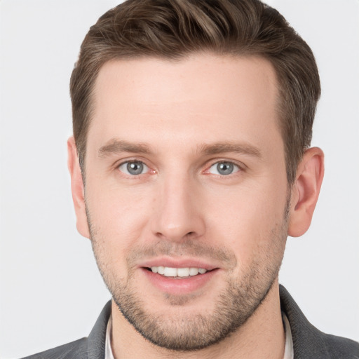 Joyful white young-adult male with short  brown hair and grey eyes