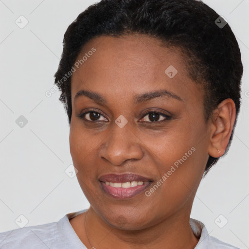 Joyful black young-adult female with short  brown hair and brown eyes