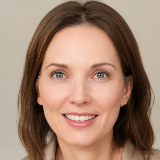 Joyful white young-adult female with medium  brown hair and green eyes