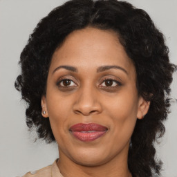 Joyful black adult female with medium  brown hair and brown eyes