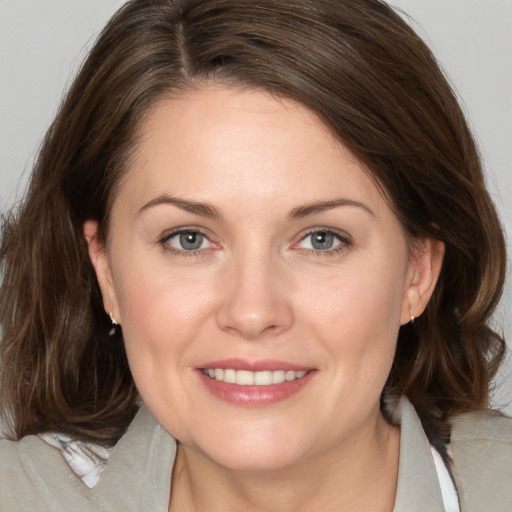 Joyful white adult female with medium  brown hair and grey eyes