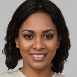 Joyful black young-adult female with medium  brown hair and brown eyes