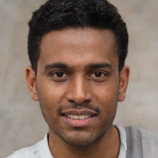 Joyful black young-adult male with short  black hair and brown eyes