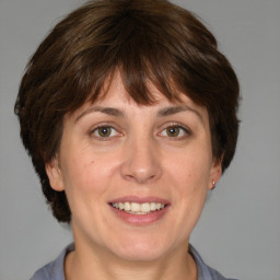 Joyful white adult female with medium  brown hair and grey eyes