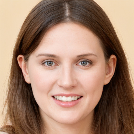 Joyful white young-adult female with long  brown hair and grey eyes