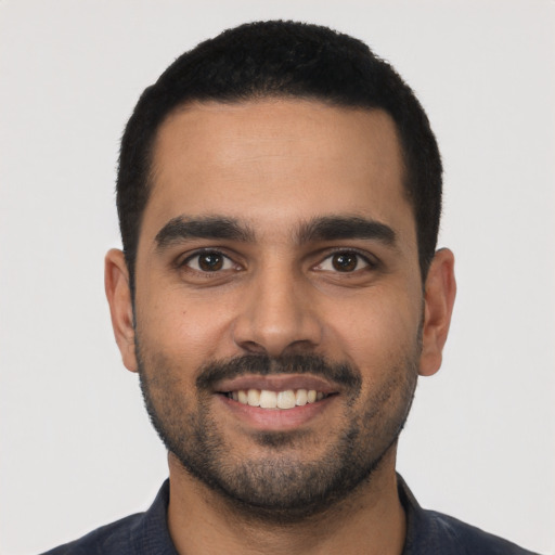 Joyful latino young-adult male with short  black hair and brown eyes