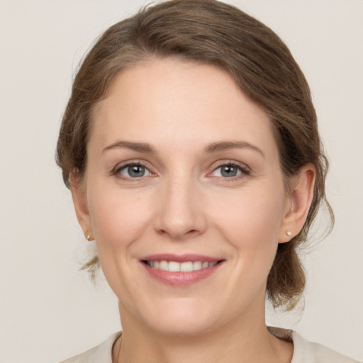 Joyful white young-adult female with medium  brown hair and grey eyes