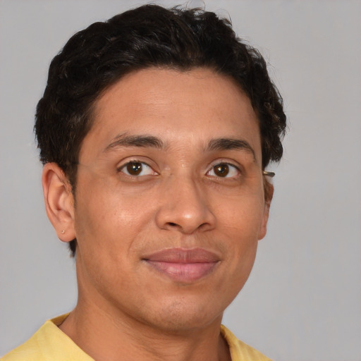 Joyful latino young-adult male with short  brown hair and brown eyes