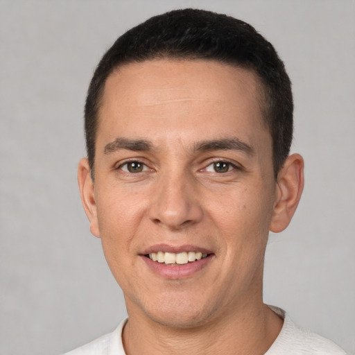 Joyful white young-adult male with short  black hair and brown eyes