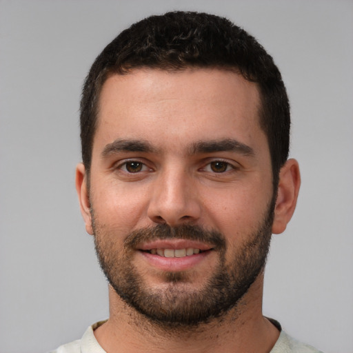 Joyful white young-adult male with short  black hair and brown eyes