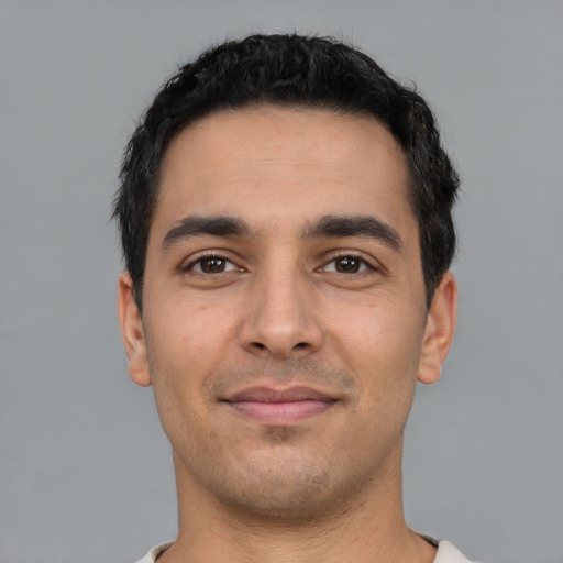 Joyful latino young-adult male with short  black hair and brown eyes