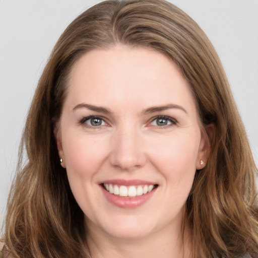 Joyful white young-adult female with long  brown hair and grey eyes