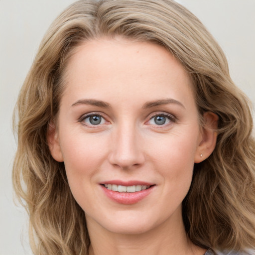 Joyful white young-adult female with long  brown hair and blue eyes