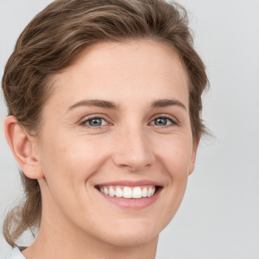 Joyful white young-adult female with short  brown hair and grey eyes