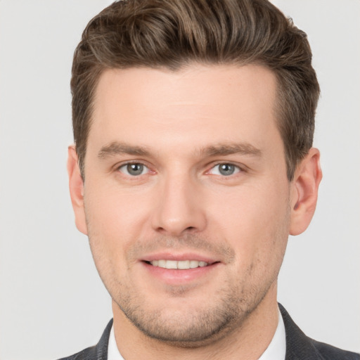 Joyful white young-adult male with short  brown hair and grey eyes