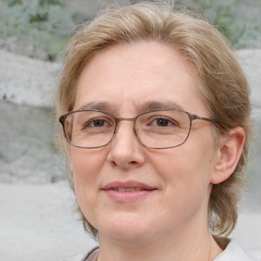 Joyful white middle-aged female with medium  brown hair and blue eyes