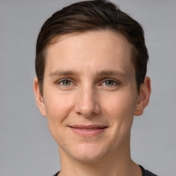 Joyful white young-adult male with short  brown hair and grey eyes