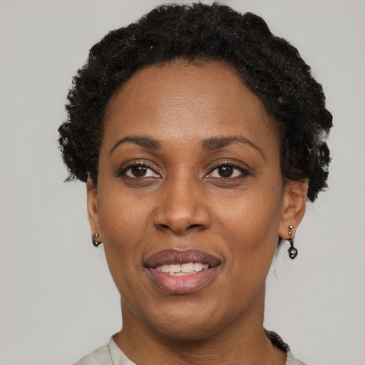 Joyful black adult female with short  black hair and brown eyes