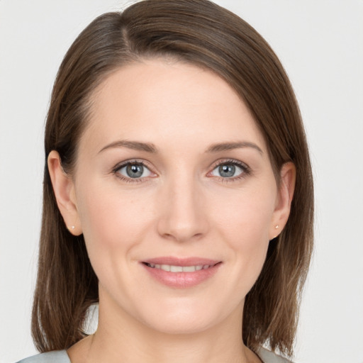 Joyful white young-adult female with medium  brown hair and grey eyes