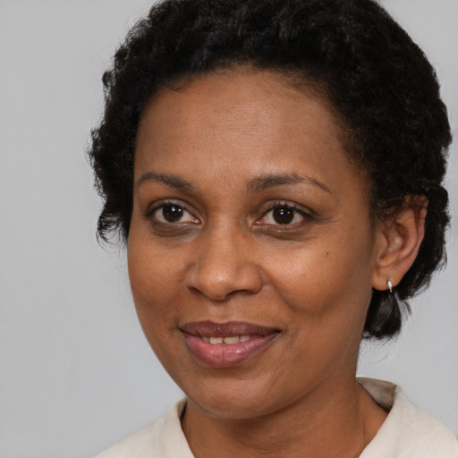 Joyful black adult female with medium  brown hair and brown eyes
