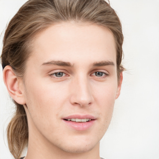 Joyful white young-adult male with long  brown hair and grey eyes