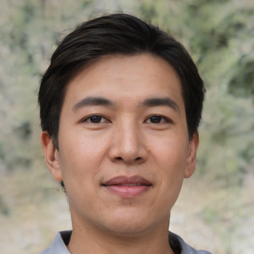 Joyful asian young-adult male with short  black hair and brown eyes