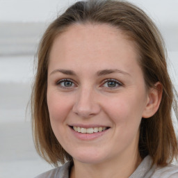 Joyful white young-adult female with medium  brown hair and blue eyes