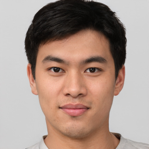 Joyful asian young-adult male with short  black hair and brown eyes