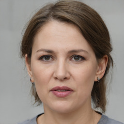 Joyful white adult female with medium  brown hair and grey eyes