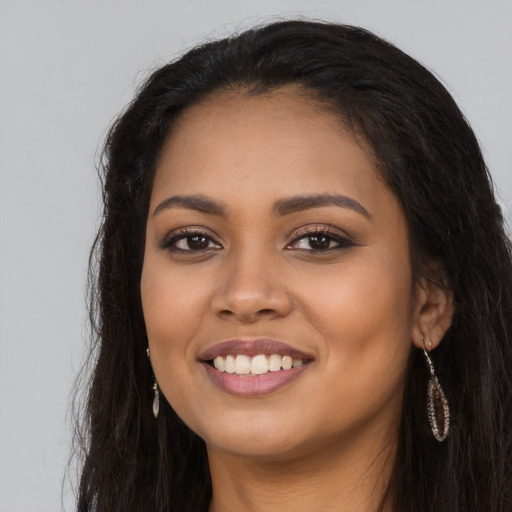Joyful latino young-adult female with long  black hair and brown eyes
