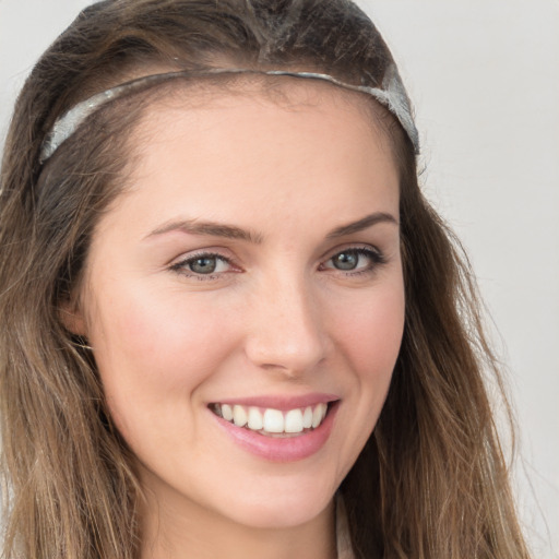 Joyful white young-adult female with long  brown hair and grey eyes