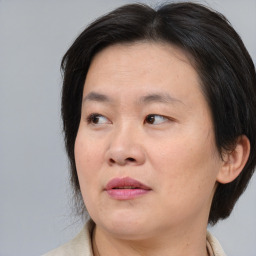 Joyful asian adult female with medium  brown hair and brown eyes