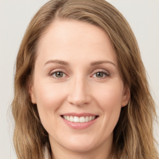 Joyful white young-adult female with long  brown hair and green eyes