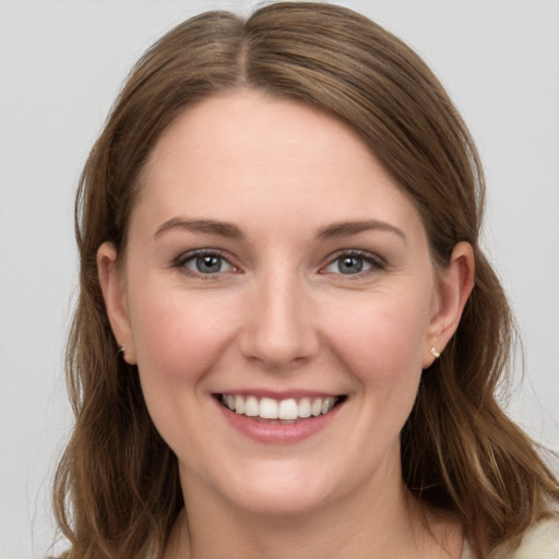 Joyful white young-adult female with long  brown hair and grey eyes