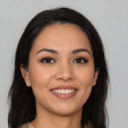 Joyful latino young-adult female with long  brown hair and brown eyes