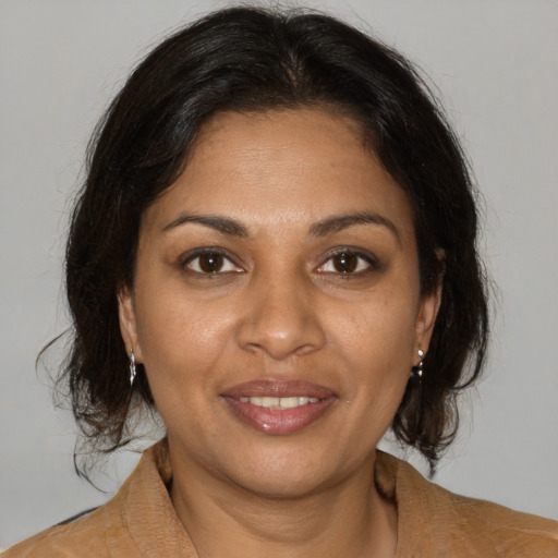 Joyful black adult female with medium  brown hair and brown eyes