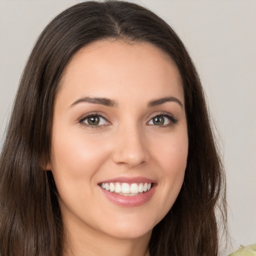 Joyful white young-adult female with long  brown hair and brown eyes