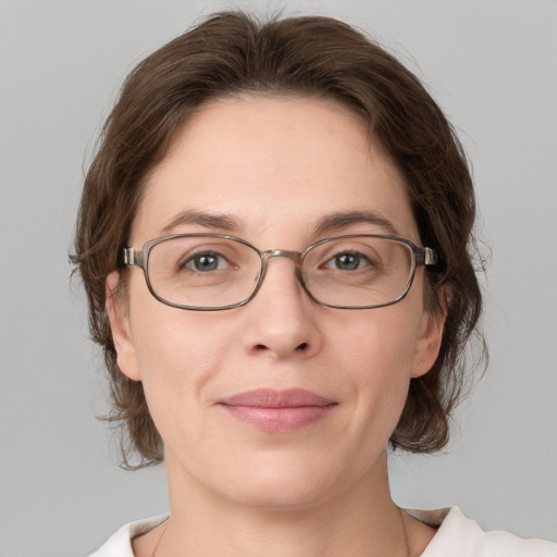 Joyful white adult female with medium  brown hair and grey eyes