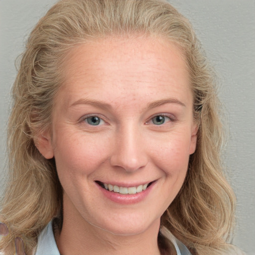 Joyful white young-adult female with medium  brown hair and blue eyes