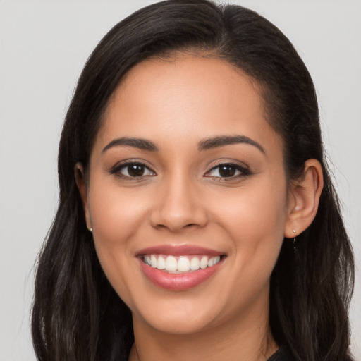 Joyful latino young-adult female with long  brown hair and brown eyes