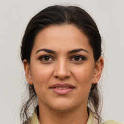 Joyful latino young-adult female with medium  brown hair and brown eyes